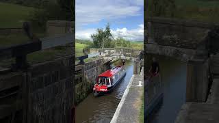 Narrowboat Norfolk cruises into the locks at Bank Newton on the Leeds and Liverpool canal waterways [upl. by Marr]