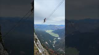 Adventurer Climbing a High Suspended Ladder with a Scenic Mountain Valley Below [upl. by Yanehc]