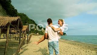 A man carrying a woman in his arms on the beach Newlyweds at the sea [upl. by Anaihsat381]