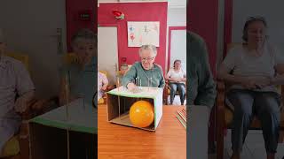 Players push long pins through a cardboard box attempting to pop the balloon [upl. by Fiske]