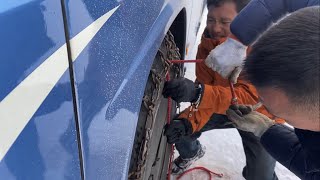 Putting chains on our bus on a snowcovered road at an elevation of 46465 meters [upl. by Curtis2]